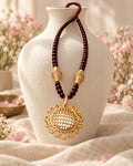 Styled image: Kattha Bell Metal Pendant Necklace Set with Maroon Beads on a white vase