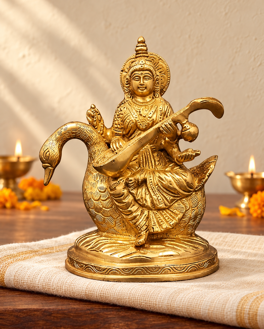 Styled image: Saraswati on Swan Brass Idol on ivory handloom with Diwali diyas